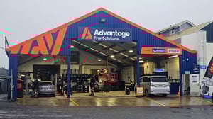 Exterior of Advantage Tyre Solutions workshop with open service bays, staff working on vehicles.