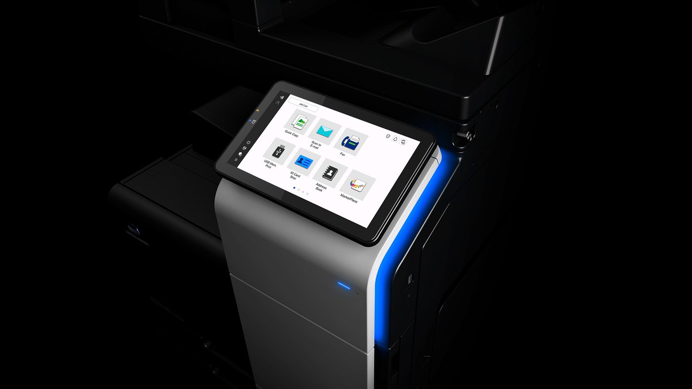 Konica Minolta bizhub multifunction printer with illuminated touchscreen panel showing print, scan and fax options.