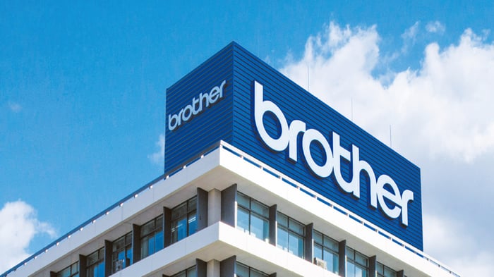 Brother corporate building with the Brother logo displayed on the rooftop against a blue sky.