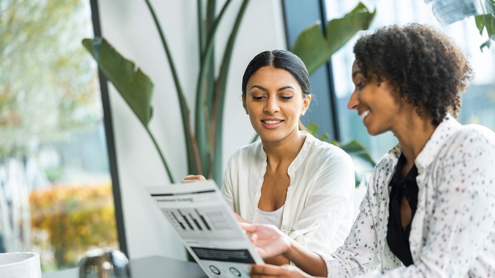 Employees reviewing printed business documents in a bright office environment