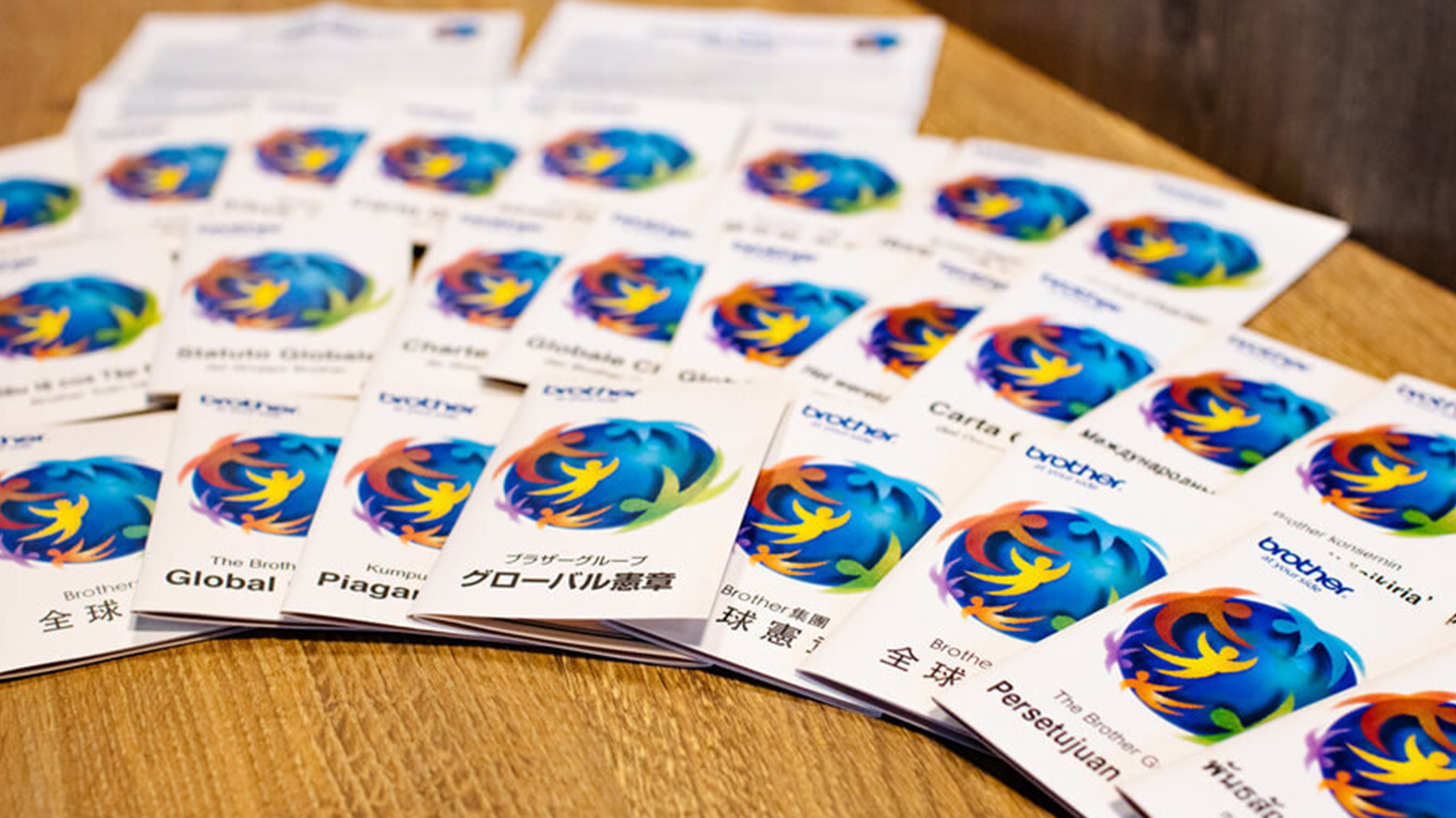 Assorted Brother Global Charter booklets displayed on a table in multiple languages.