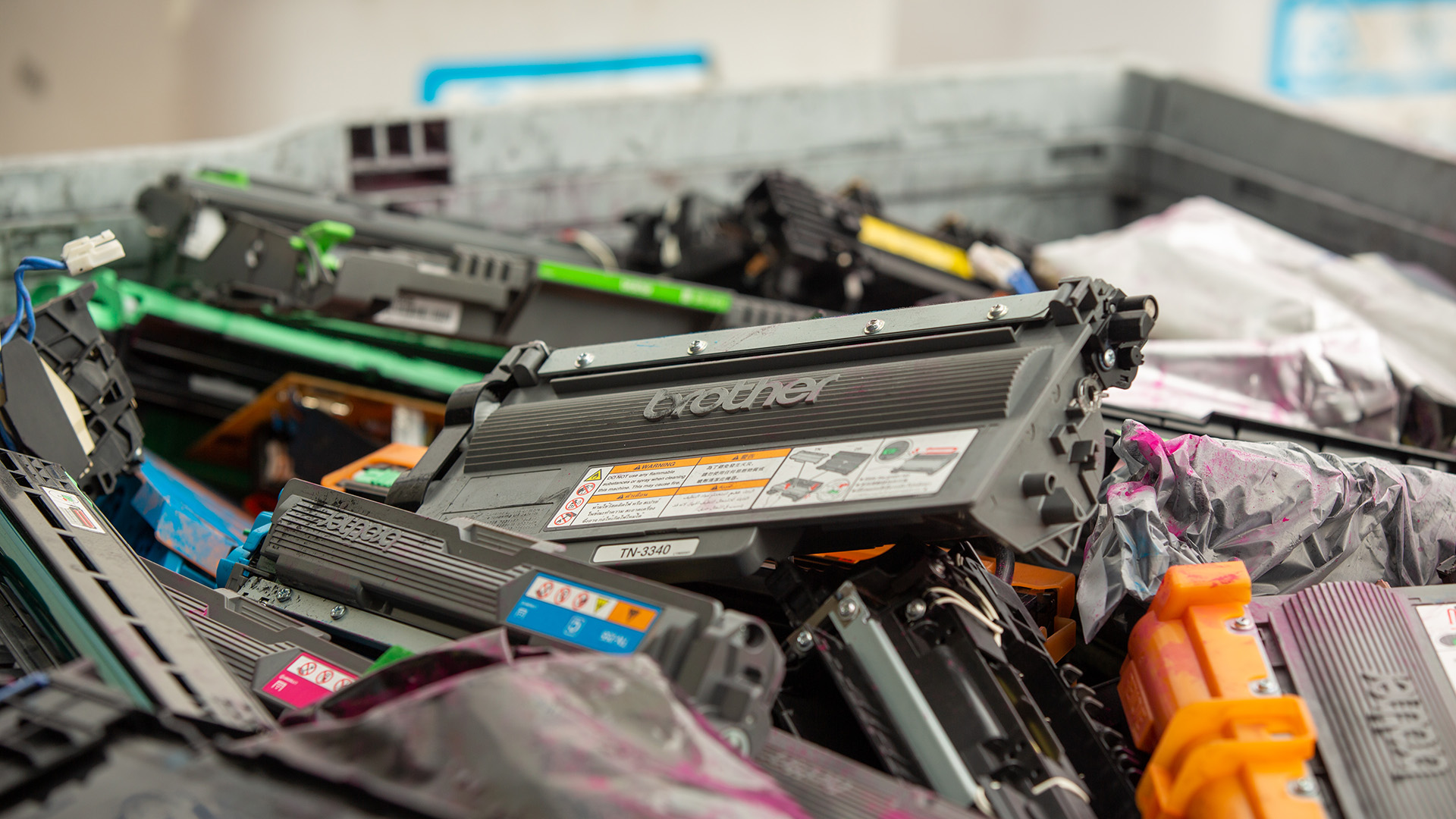 Large crate filled with assorted used Brother toner cartridges awaiting recycling.