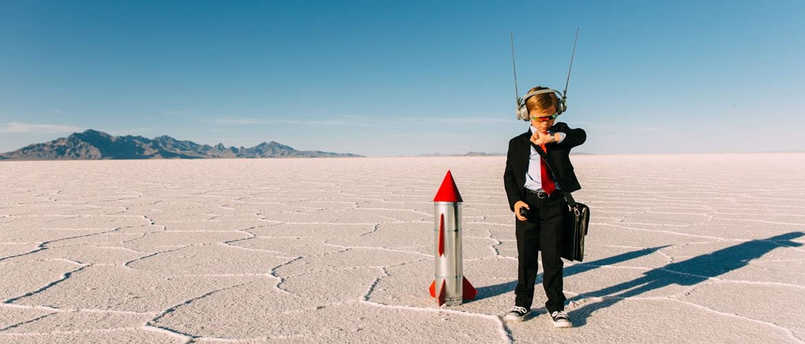 little boy in a suit prepares to launch a rocket