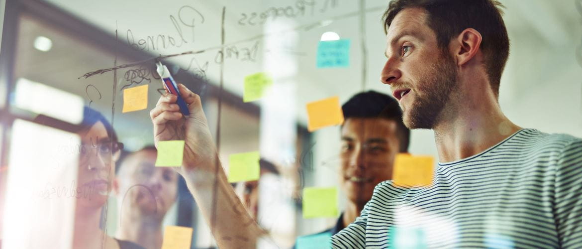 Small medium business employees working on a whiteboard