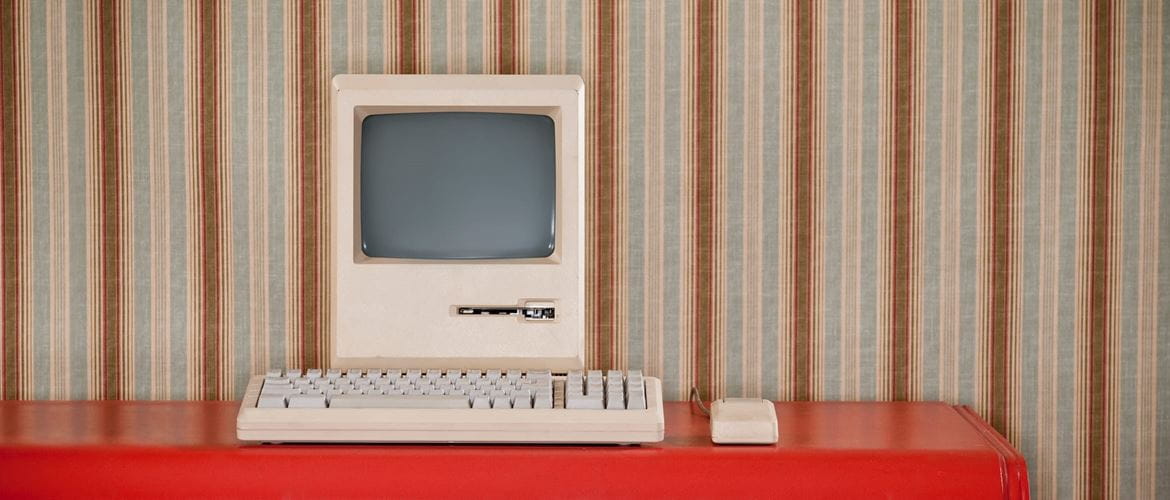 an old computer sits on a desk in a retro setting