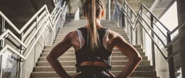 woman in gym kit prepares to run up steps