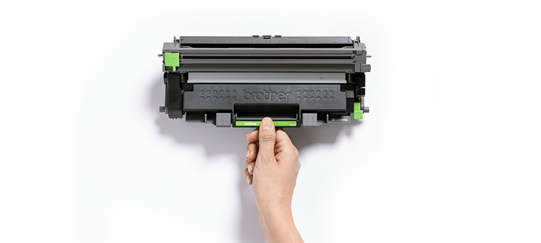A hand holding a Brother printer toner cartridge against a plain white background