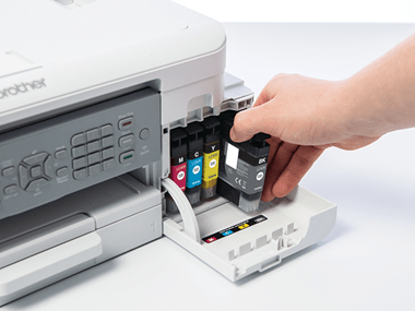 a hand replacing genuine Brother ink cartridges in a Brother printer